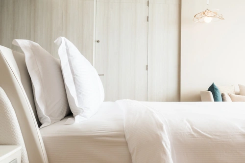Frisch bezogenes Bett in einem gereinigten, ruhigen Schlafzimmer